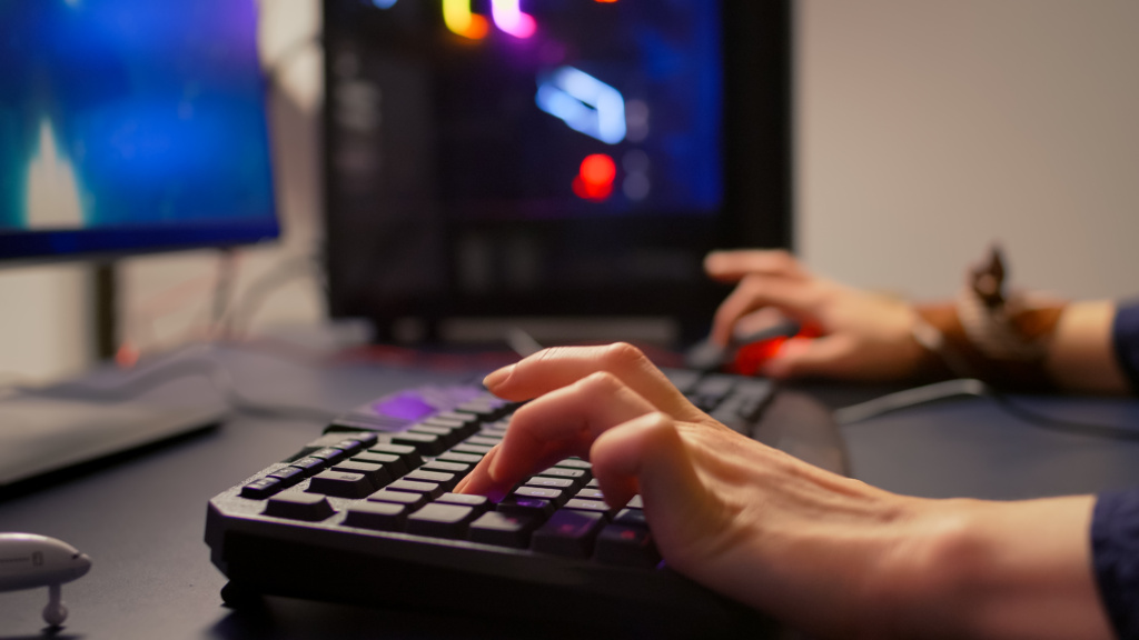 Close-up of gamer using RGB keyboard and mouse
