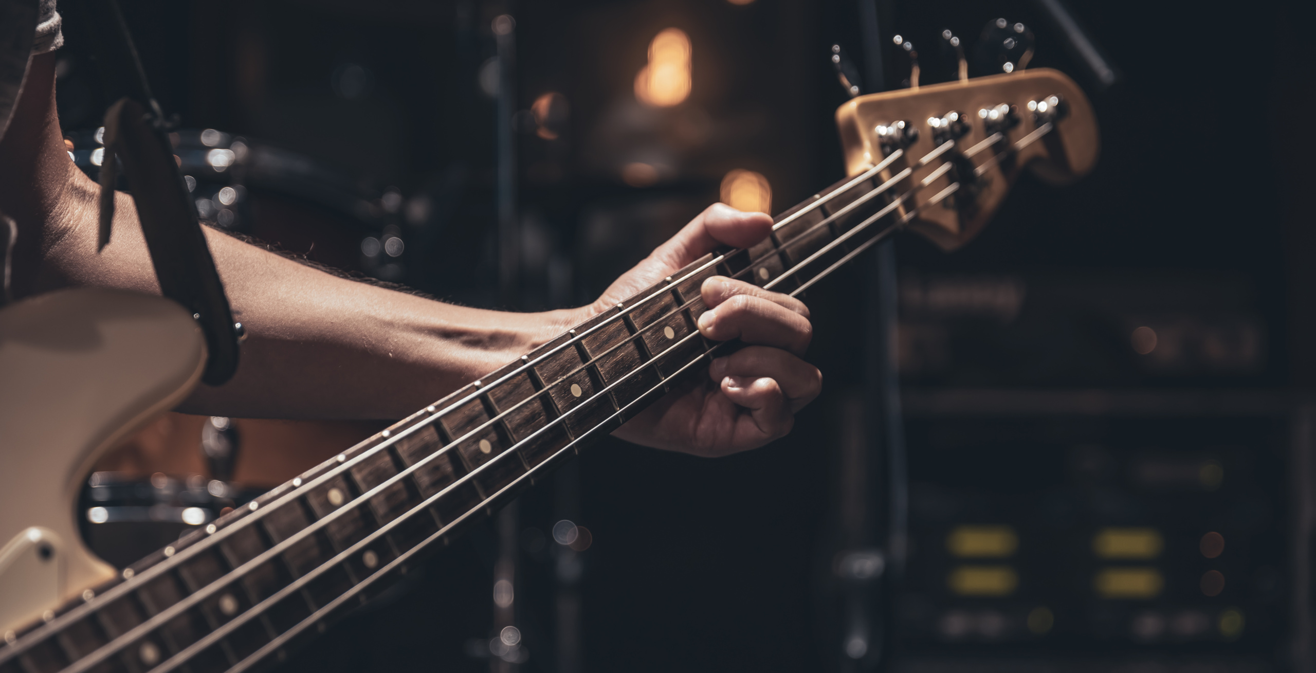 Close up of bass guitar on blurred dark background copy space.
